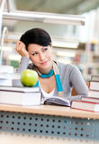 Dreamy female student studies at the reading hall Royalty Free Stock Photo