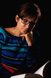 Woman reading book in dark Royalty Free Stock Photography