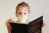Little blue eyes girl read book Stock Images