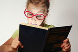 Girl in red glasses read blue book Royalty Free Stock Images