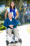Adult Daughter Pushing Senior Father In Wheelchair Stock Photos