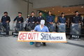 Anti government white mask protest in bangkok a protester wearing a guy fawkes holds a sign as riot police standby at an rally s Stock Photos