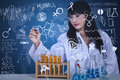 Beautiful scientist drawing formula at lab is on transparant glass with flasks and blue background Royalty Free Stock Photos