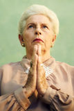 Portrait of serious old caucasian woman praying god Stock Images