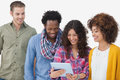 Four stylish friends looking at tablet on white background Royalty Free Stock Image