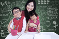 Happy family posing in class with mother and children Stock Images