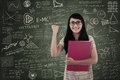 Happy female student in class on written board asian with arm raised Stock Photo