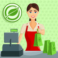 Smiling cashier girl at eco green store supermarket handing out bag Royalty Free Stock Photo