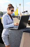 Woman with computer on quay Royalty Free Stock Image