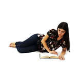 Young attractive girl lying and reading book Stock Images