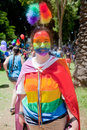 Young girl dressed up as rainbow tel aviv june with colored jacket cloak and makeup prepares to participate in gay pride Royalty Free Stock Images